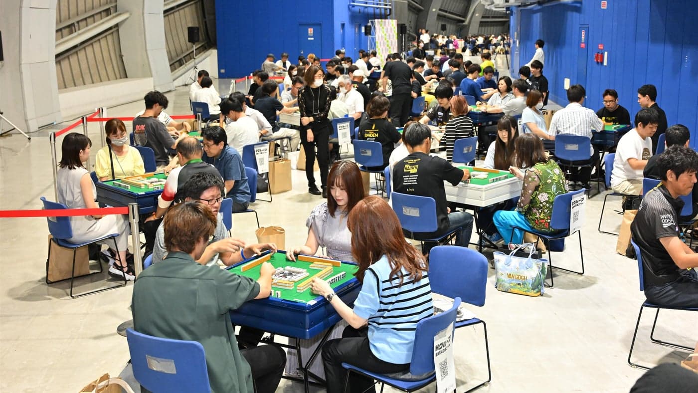 京セラドーム大阪の会場いっぱいに並んだ麻雀卓で対局する、大会の参加者たち